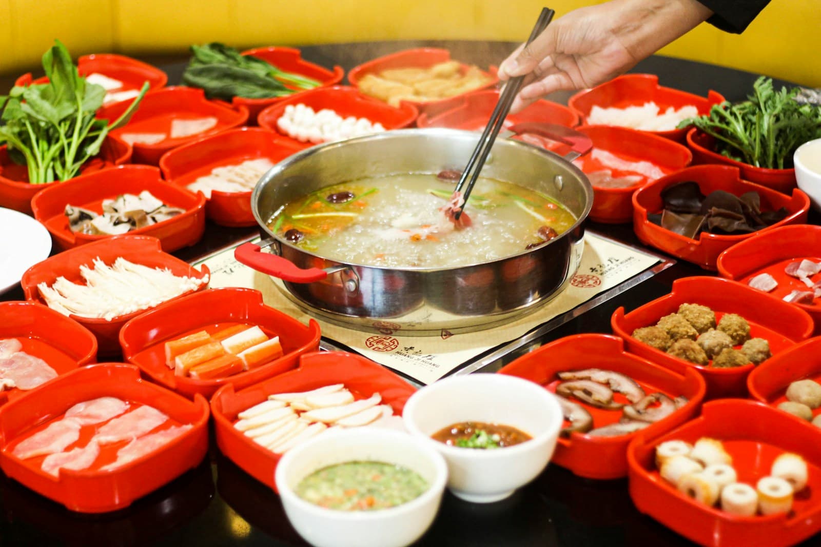 A beautifully presented Sichuan hotpot surrounded by colorful ingredients